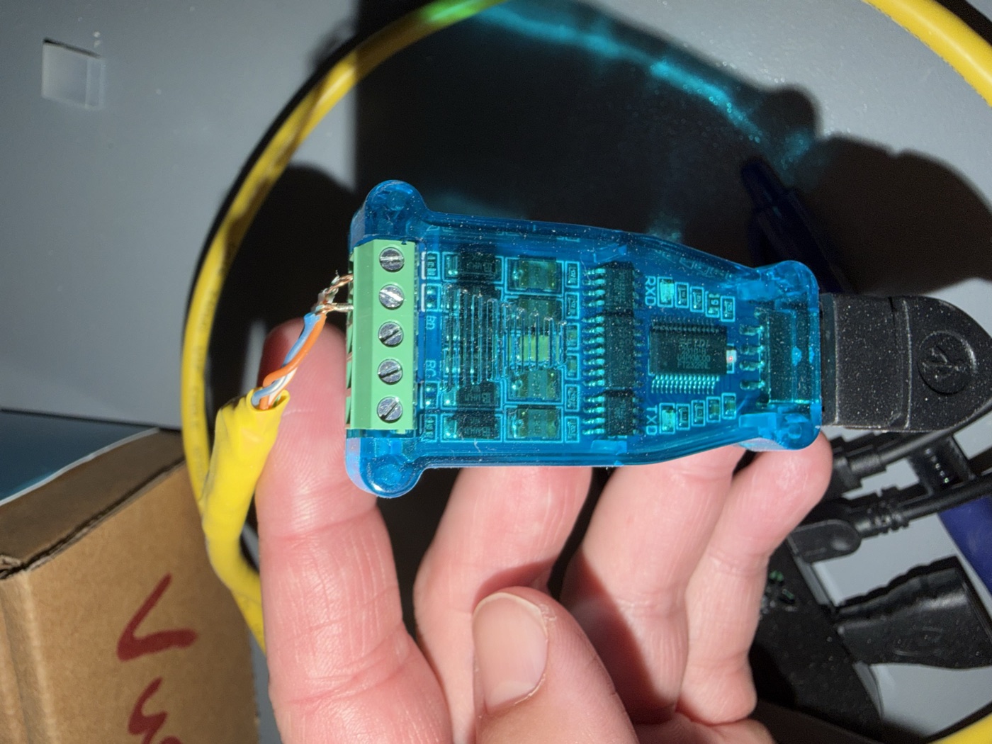 Close-up of the two twisted pairs from the Ethernet cable screwed into the adapter's green terminal block