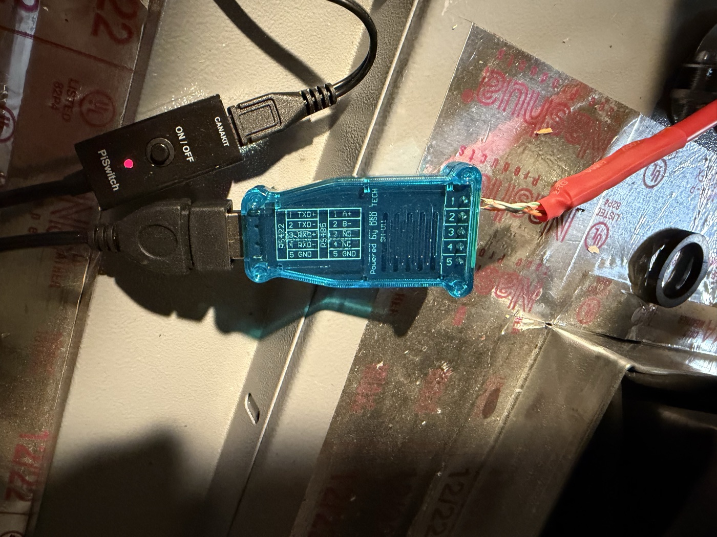 DSD TECH USB-RS485 adapter showing its printed pinout — 1 A+, 2 B-, 5 GND — with the made cable's twisted pair landed in the terminals